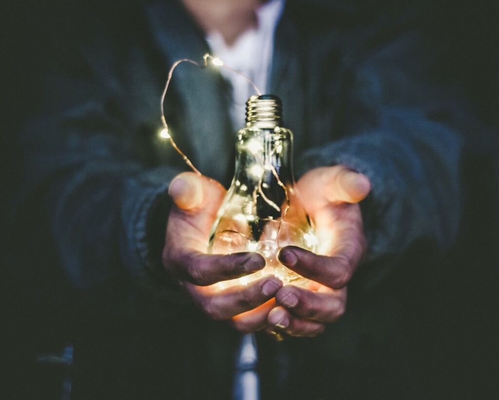 Man in a long sleeve shirt holding a lightbulb.