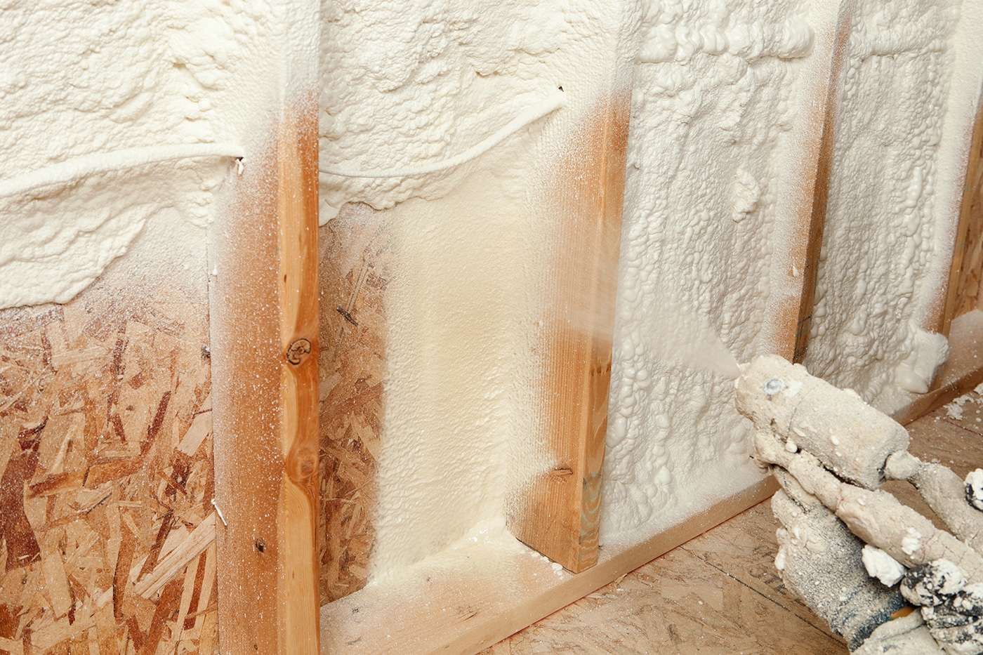 Spray foam insulation being applied in a wall cavity
