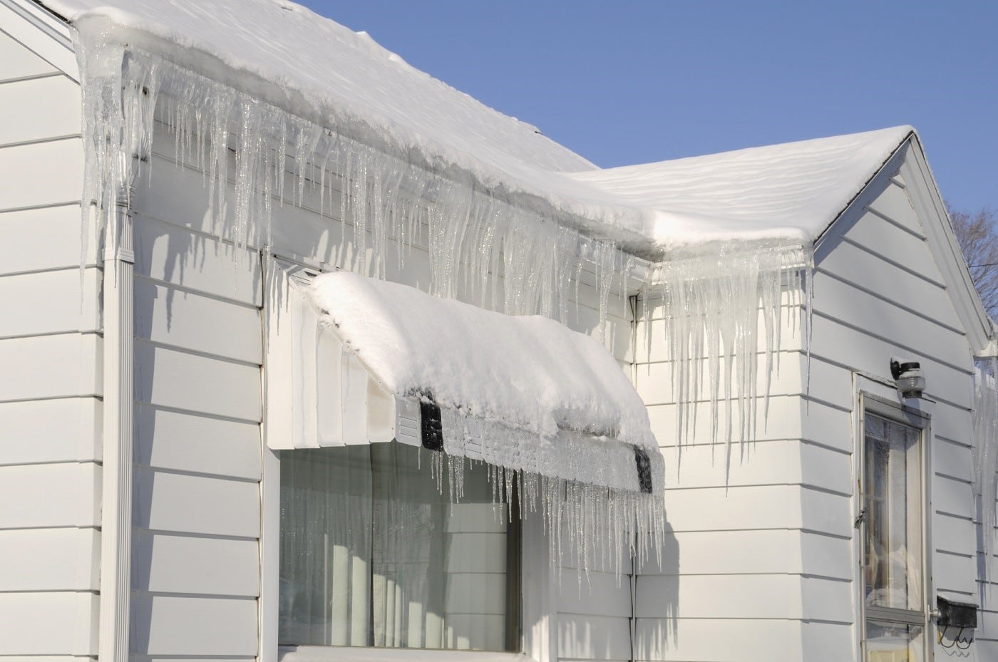 house in winter with icicles and snow on the roof