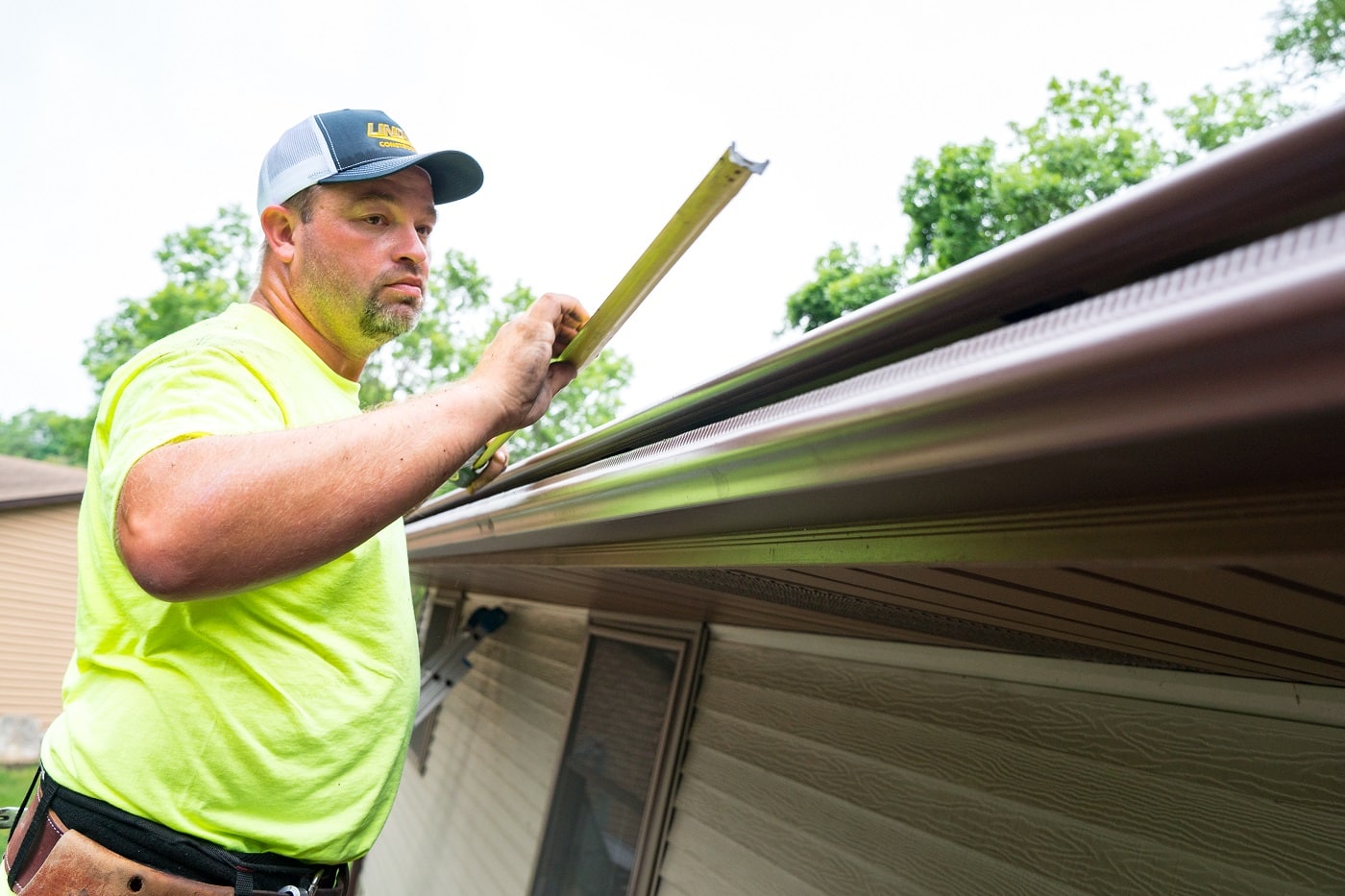 : Lindus Construction worker installing gutters on a home in the Twin Cities