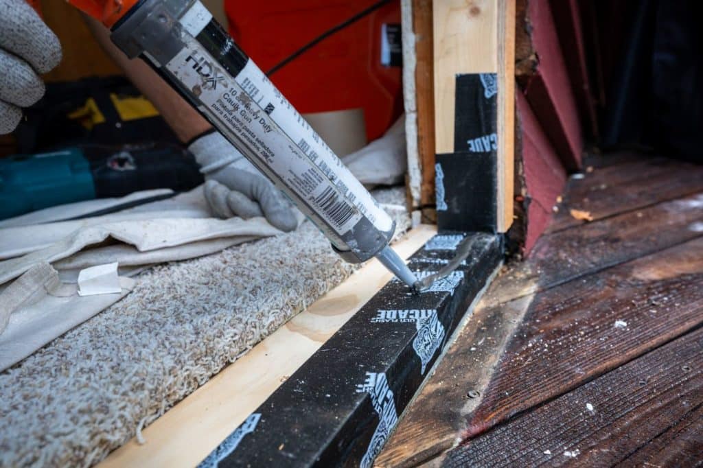 Caulk around a door frame.