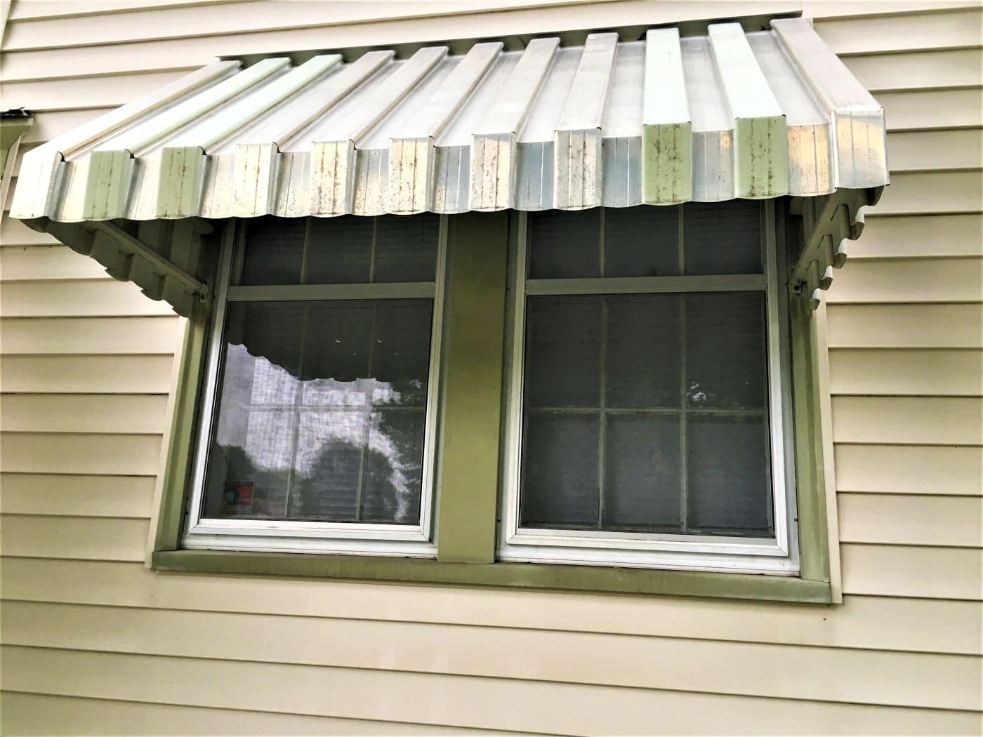 faded awning on Minneapolis home prior to window replacement