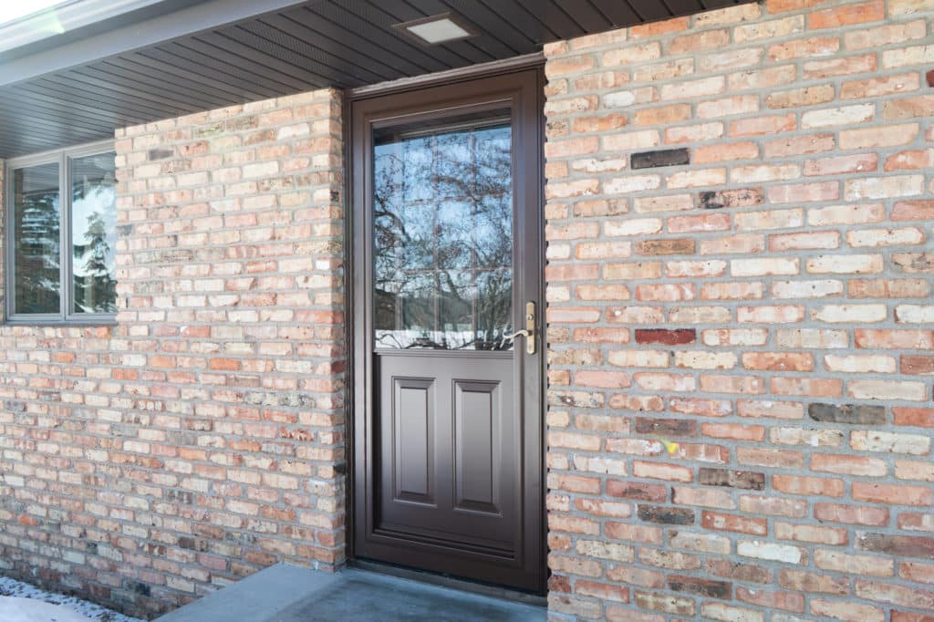 Front entry door installation on a brick home.
