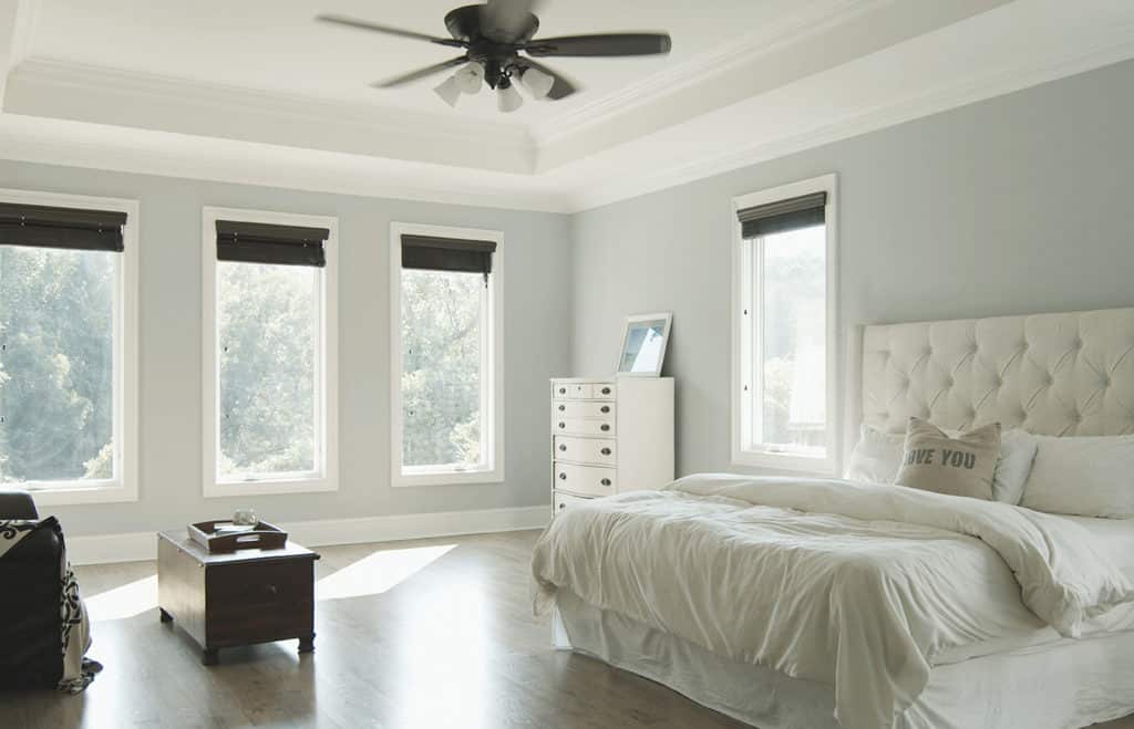 Casement window installation in a white master bedroom.