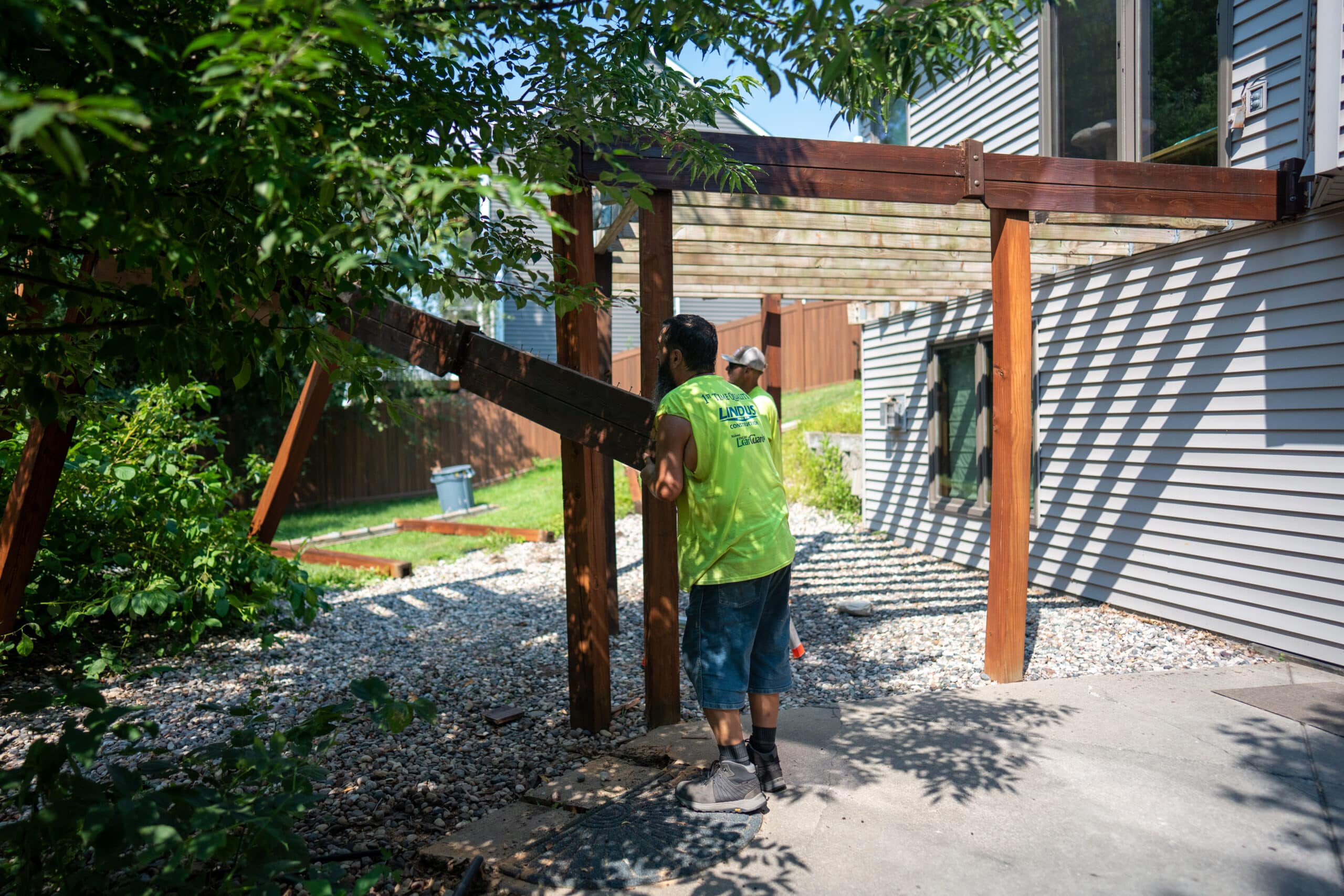 Lindus Construction craftsmen installing TimberTech AZEK® deck boards on an elevated residential deck in Eden Prairie, MN.