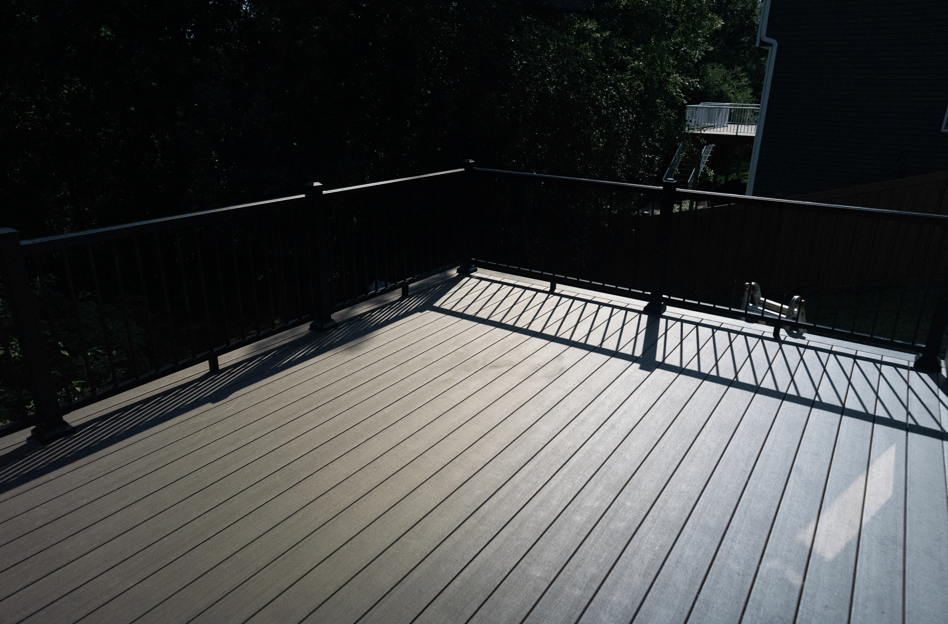 TimberTech® AZEK® Landmark Collection decking in American Walnut with black aluminum railings on a completed deck in Eden Prairie, MN.